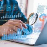 Businessman,Holding,Magnifying,Glass,Looking,At,Virtual,Data,Chart,Dashboard